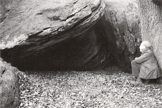 Abb. 20: Der kleinere der beiden Abris. Blick von Süden in die hier beginnende Eulenschlucht; der Eingang in die Überdeckungs- Durchgangshöhle ist rechts neben dem Baumstamm, an den sich der Verf. lehnt. (Foto: Werner Suer) 